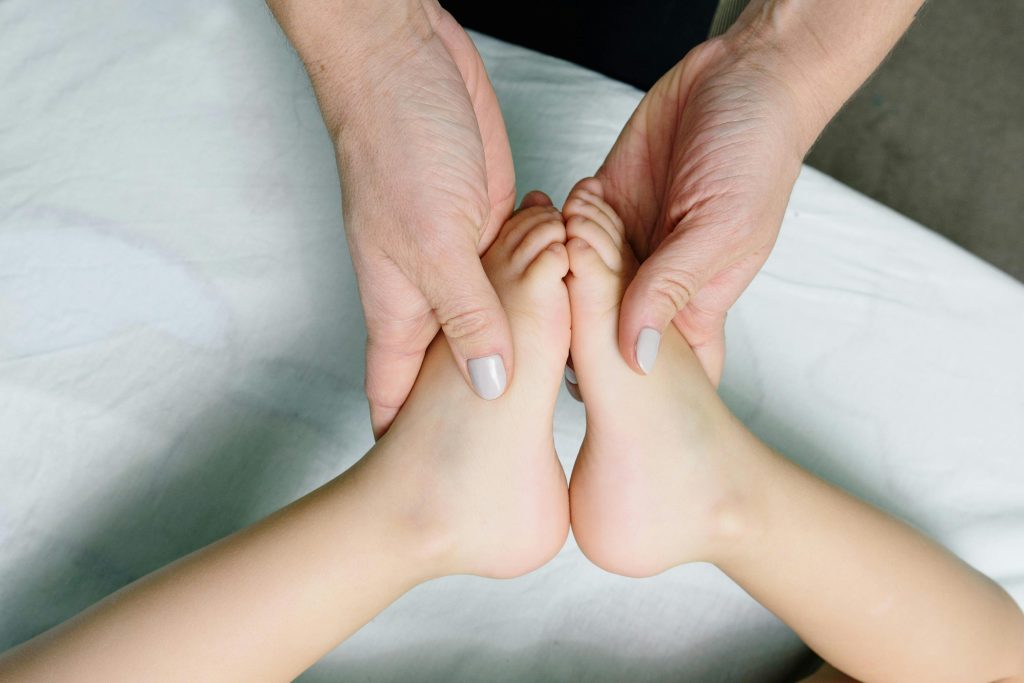 Adult hands gently massaging baby feet. Perfect representation of care and relaxation.
